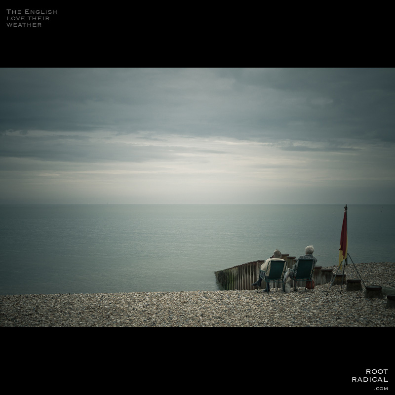 the-english-love-their-weather Two elder people sitting on british sea during cloudy weather.