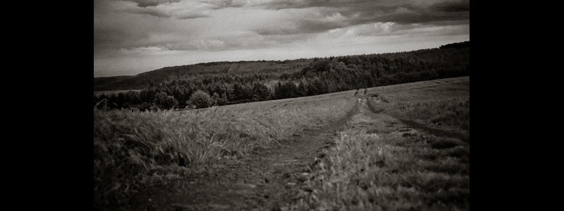 Black an white photo of trail through a rural landscape.